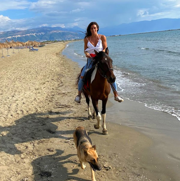 Woman horseback riding on the beach